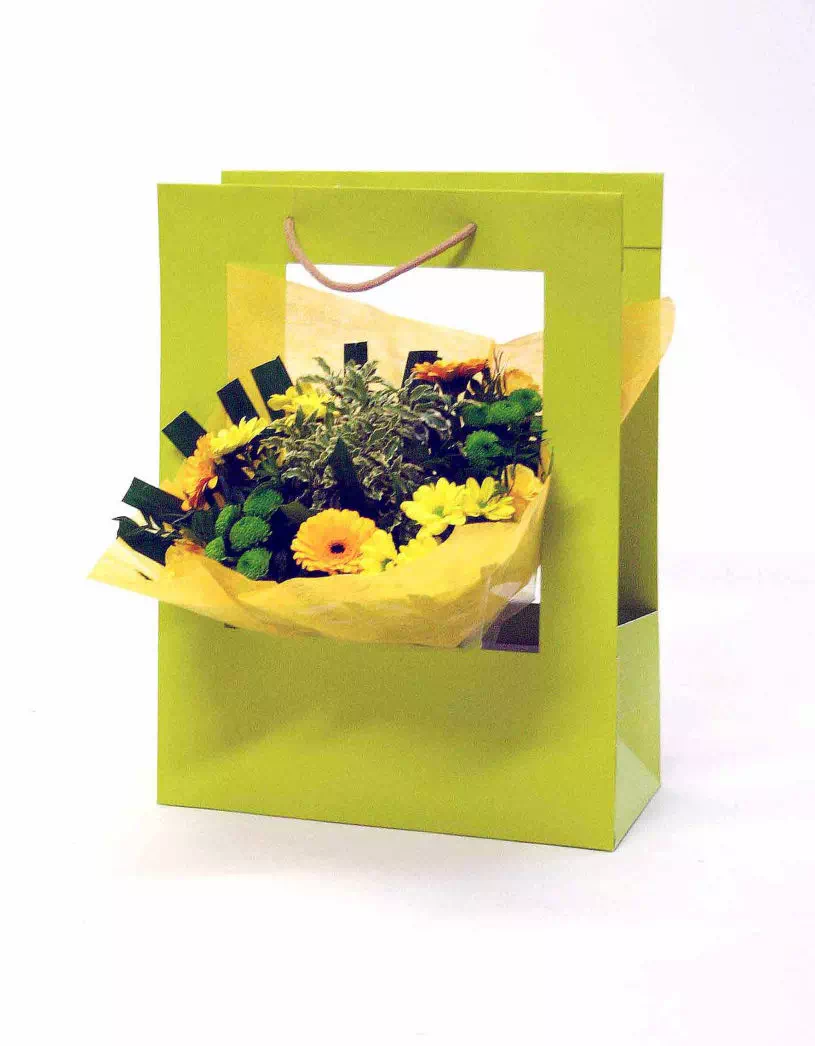 bouquet de fleurs jaune présenté dans un sac vert à fenêtre