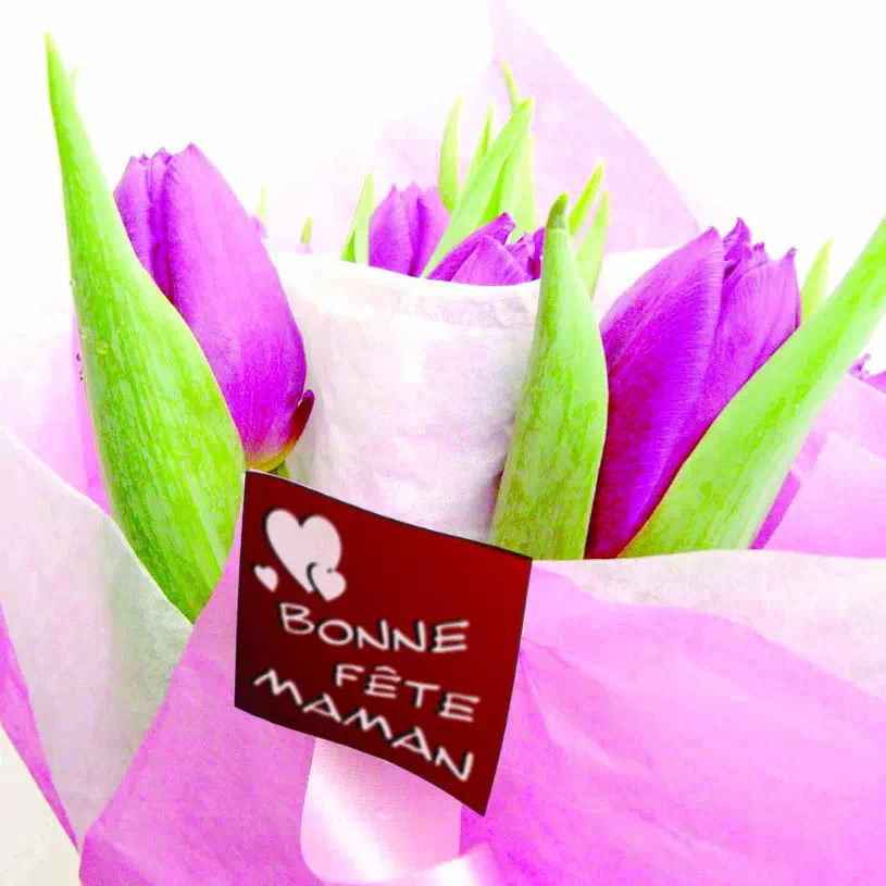 photo d'une étiquette à message "Bonne fête maman" collé sur un bouquet de tulipes violettes.