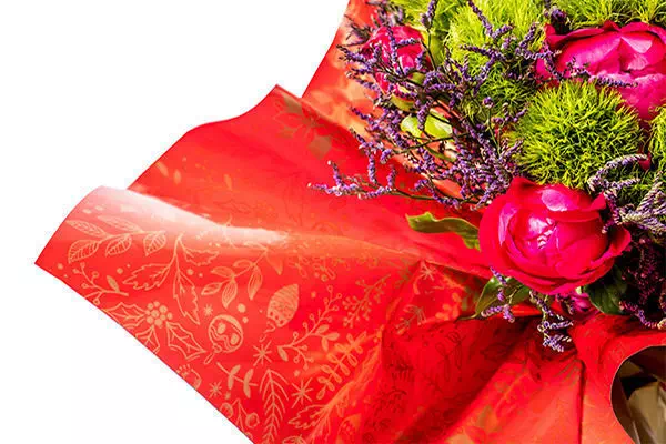 photo d'un bouquet de fleurs emballé dans du film polypro opaque et brillant rouge.