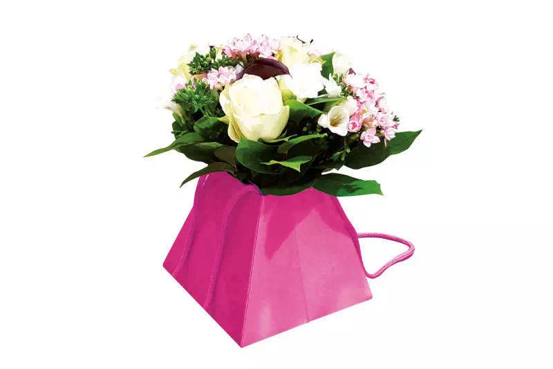 sac luxe pour fleuriste en forme de trapèze rose avec poignées cordelettes et bouquet de fleurs blanches et rose.